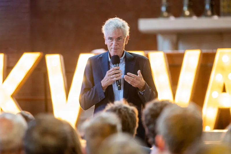 Spreker met microfoon voor lichtletters tijdens een bedrijfsfeest
