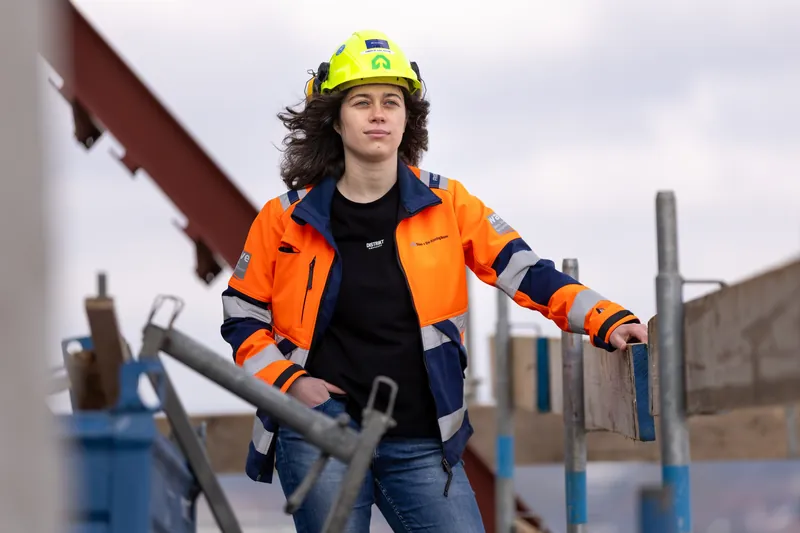 Bedrijfsreportage: bouwprofessional op een balkon van een gebouw in aanbouw