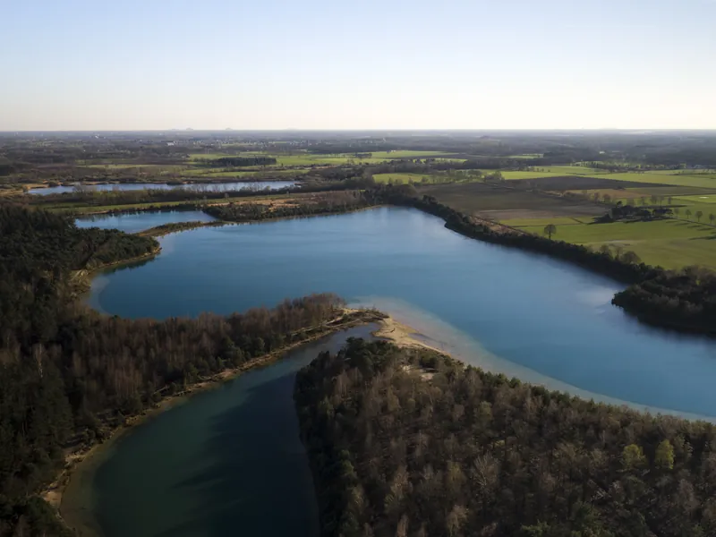 Dronefoto van een ven omringd door bos en weiland
