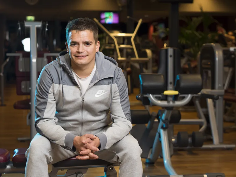 Portret van een man in sportkleding zittend in een sportschool