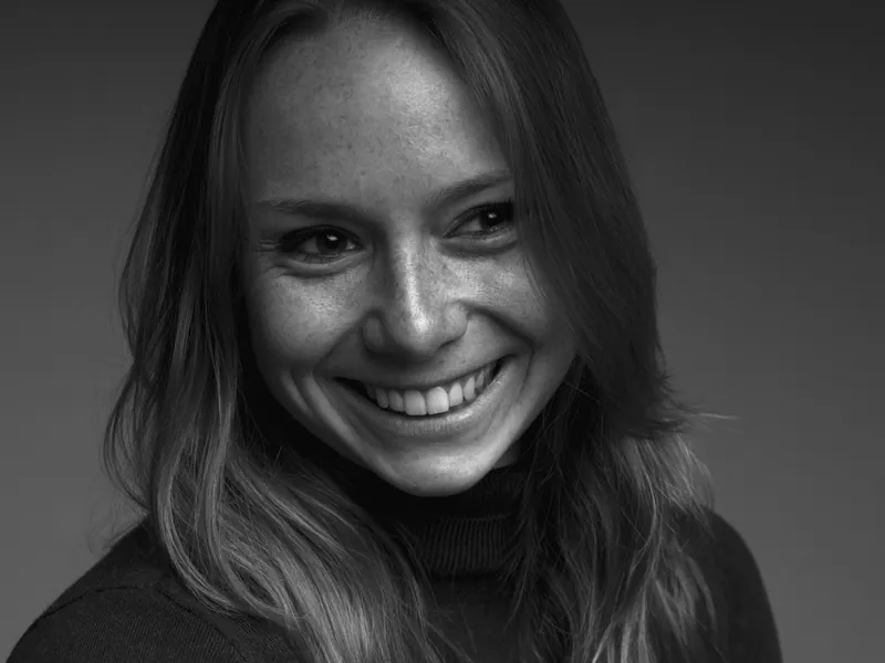 Zwart-wit portret van een lachende vrouw met sproeten
