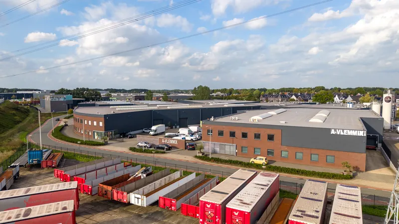 Dronefoto van een bedrijfspand naast de snelweg met containers op het terrein