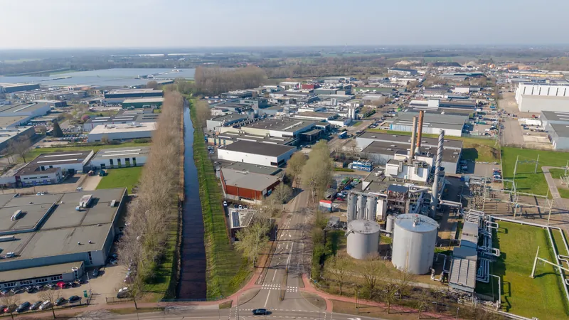 Dronefoto van een bedrijventerrein met een kanaal dat door het beeld loopt