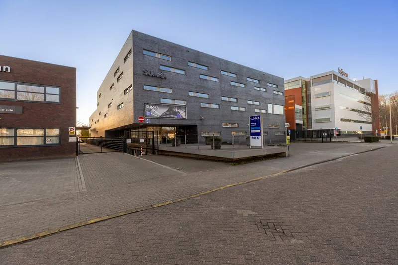 Bedrijfsgebouw met opvallende gevel in het avondlicht gefotografeerd vanaf de grond