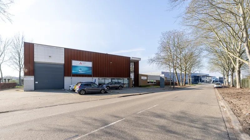 Bedrijfspand met rode gevel gefotografeerd vanaf de straat