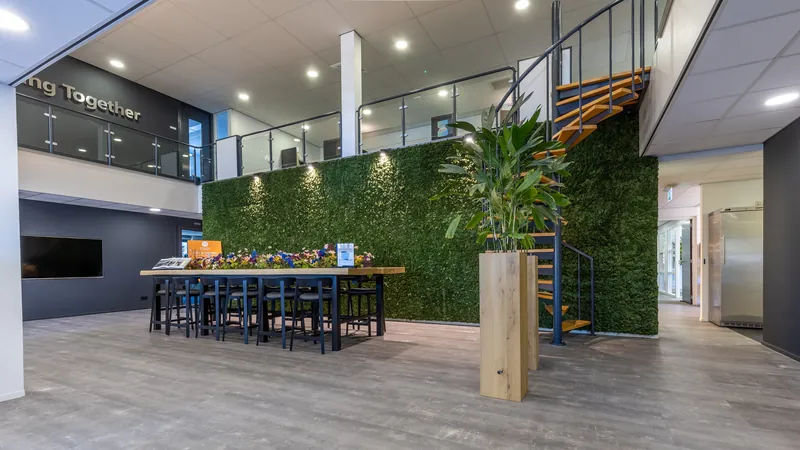 Interieur van een kantoor met open verdieping, trap en groene wand