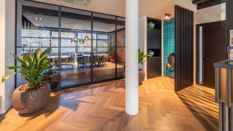 Interieur van een kantoor met receptie, glazen wanden en planten